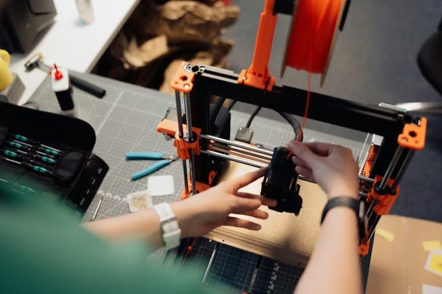 A person building a prototype using a 3D printer