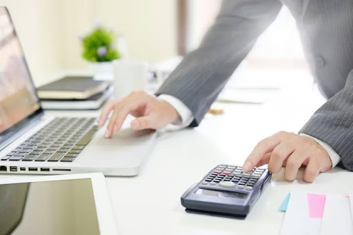 A tech professional calculates the financial cost of a patent on a calculator.