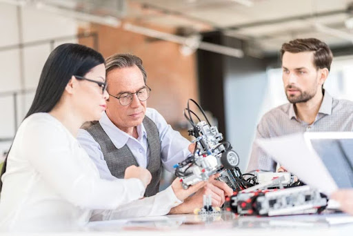 Three business professionals reviewing a patent novelty analysis for a new product invention.