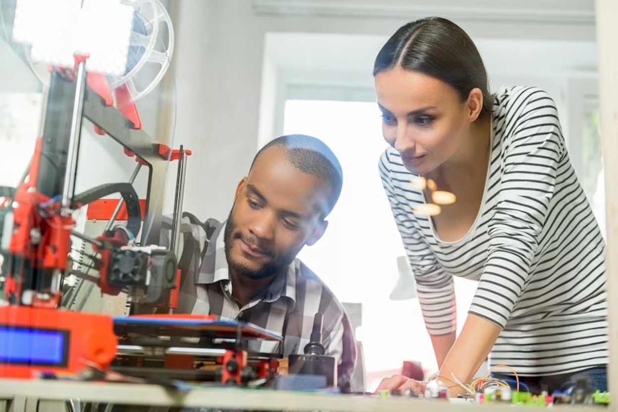 Young tech professionals using a 3D printer for prototyping