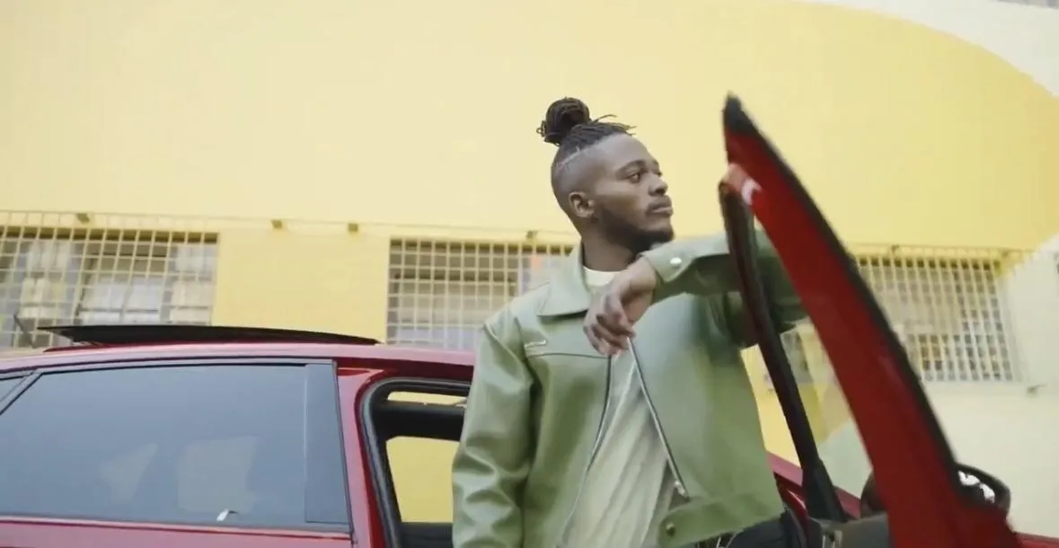 On-location product advert featuring Thabang beside a sleek vehicle with moody editorial tones.