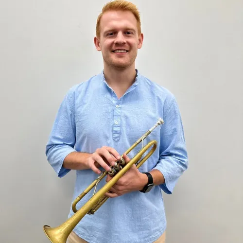 Alex Hales holding a trumpet.