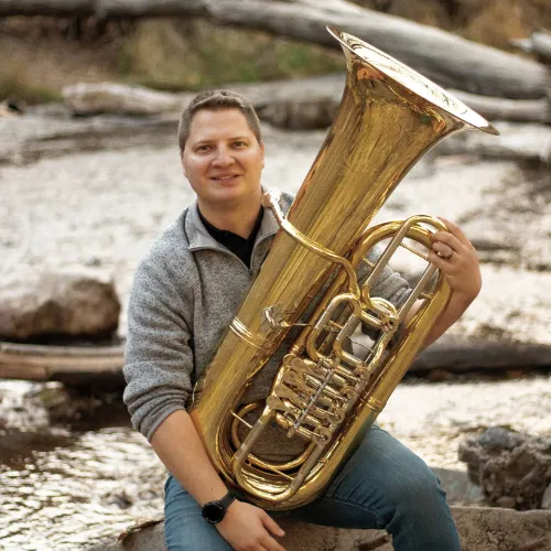 Thomas Kinder holding a tuba.