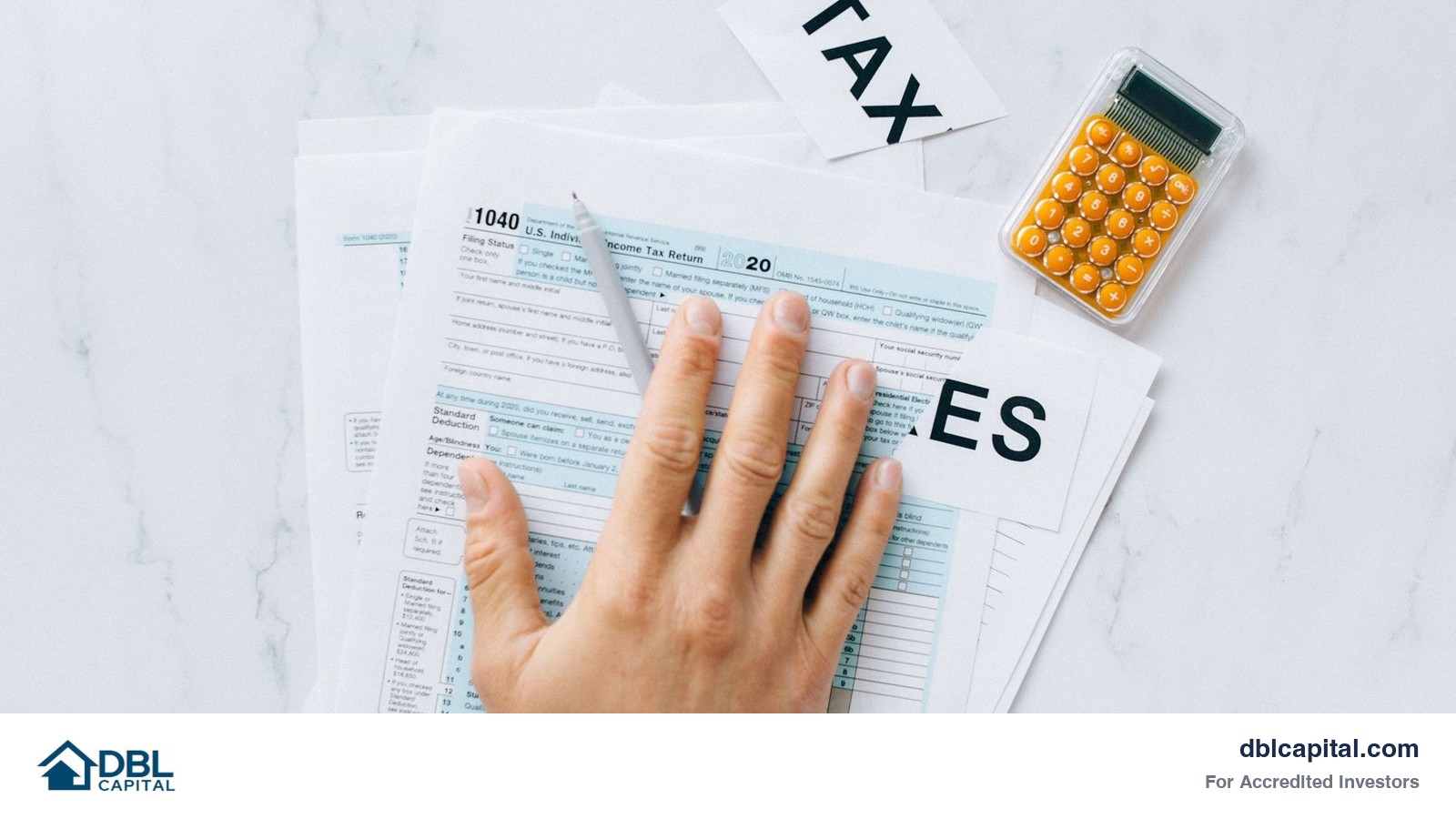 Hand resting on a Form 1040 tax return beside a calculator on a marble desk