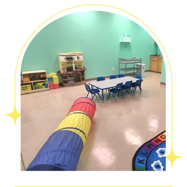 Image of classroom with play tunnel and tble and chairs