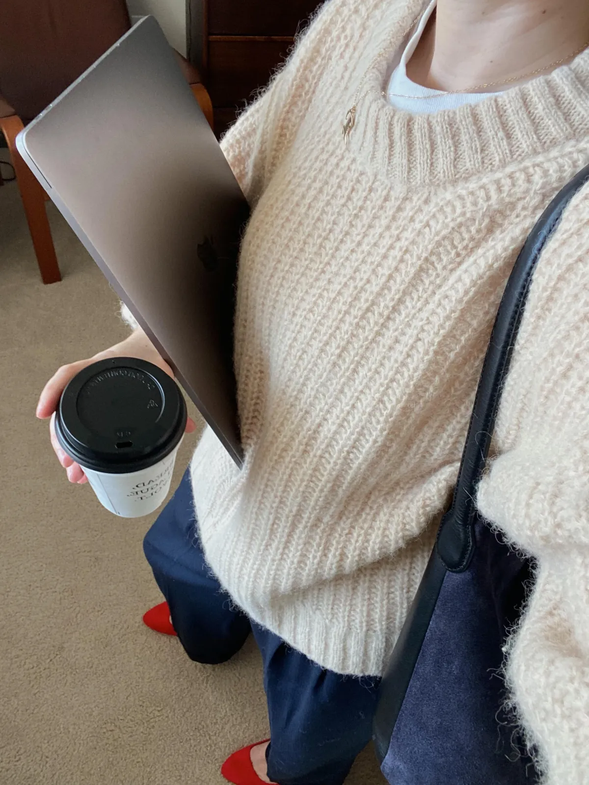 woman carrying a laptop and a coffee