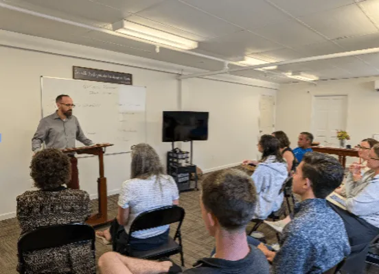 Instructor leads a classroom discussion while Worldview Institute students and attendees listen during an interactive learning session.