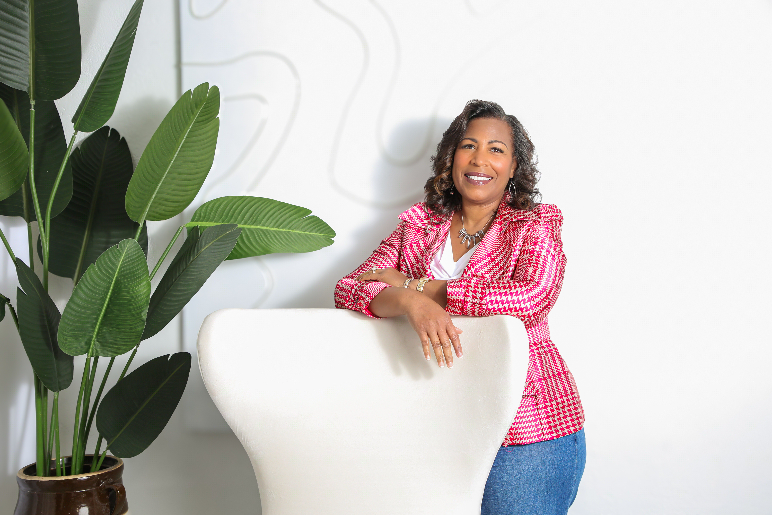 A group of diverse women in soft pastel attire, standing together in a sunlit open space, smiling and looking inspired. The background is softly blurred, evoking warmth and unity.