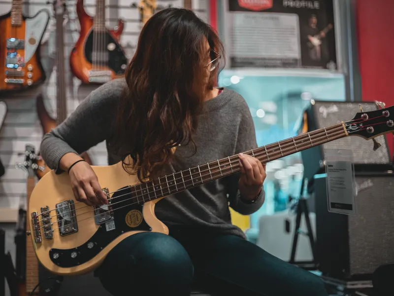 Teen girl focus learning Bass guitar lesson at Lochwood Academy