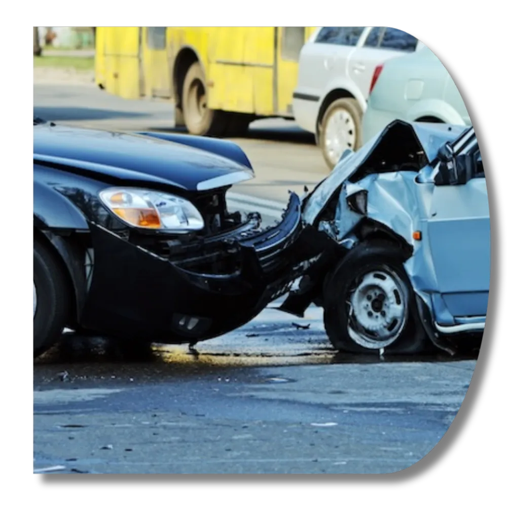 Head-on collision between two cars with severe front-end damage on a city street.