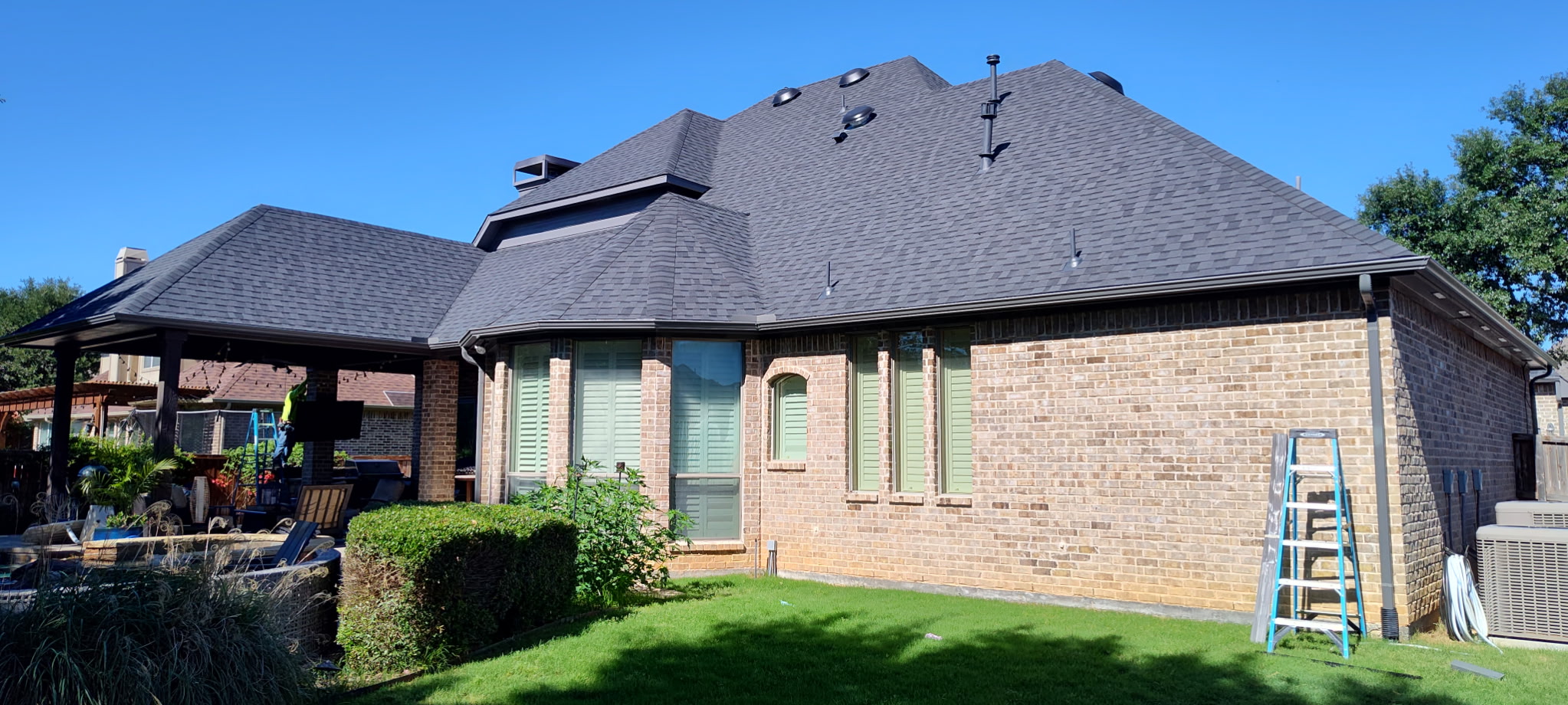 Technician installing seamless rain gutters on a residential home