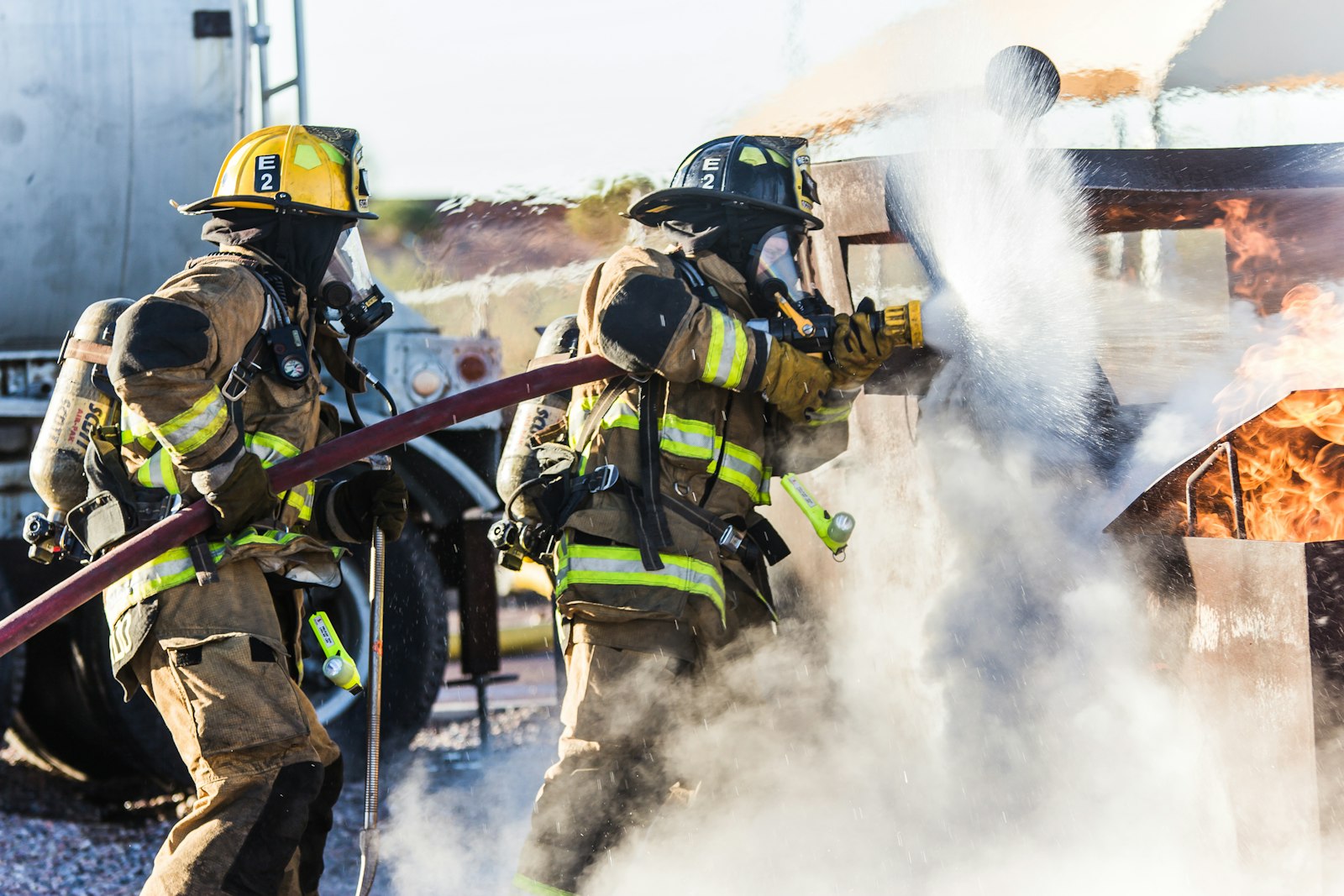 Two firefighters in full gear during a live fire training exercise