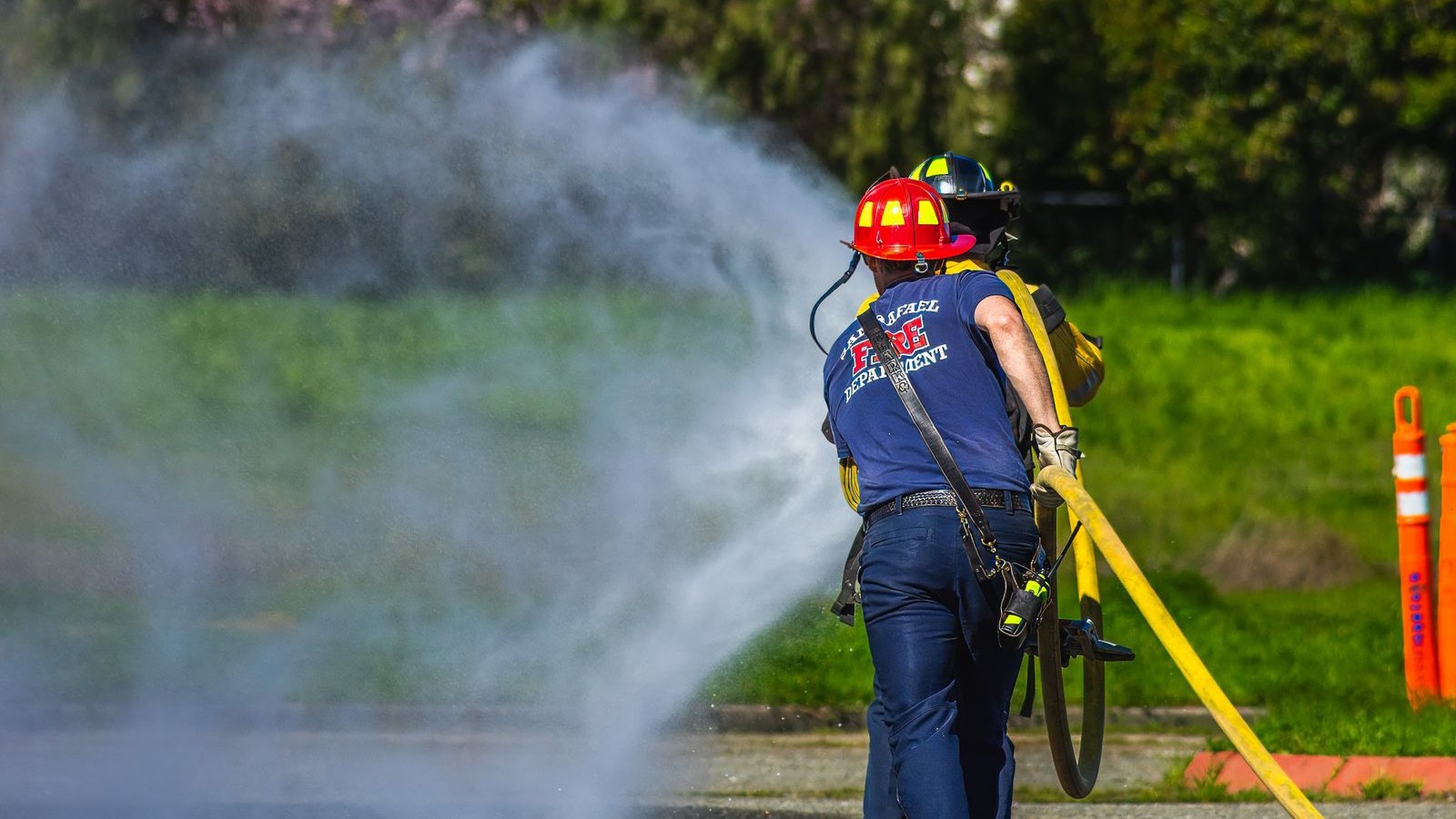 Firefighters running a hose line during an outdoor training drill
