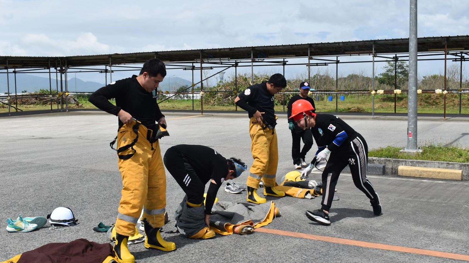 Emergency responders donning turnout gear during an outdoor training exercise