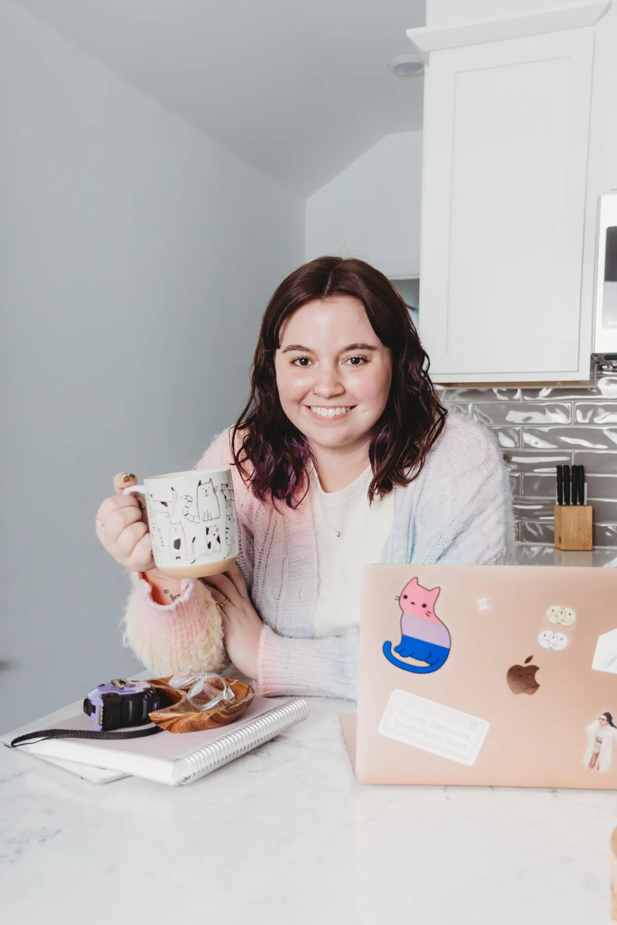 home organization speciliast in austin holding a coffee cup sitting by a computer