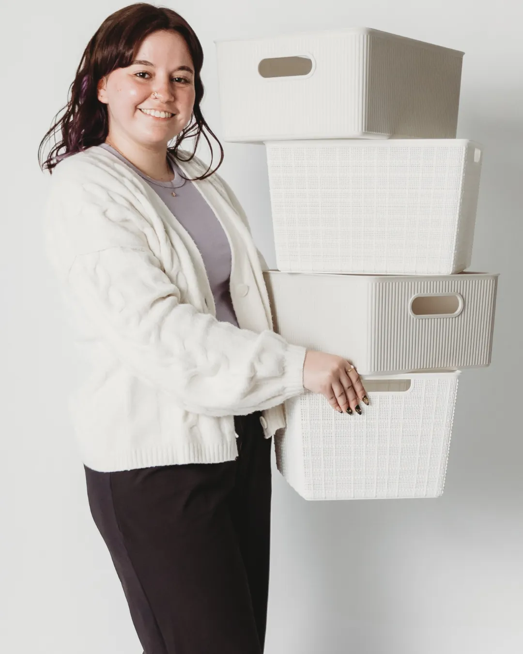 jamie smiling at camera carrying organizer bins for a closet