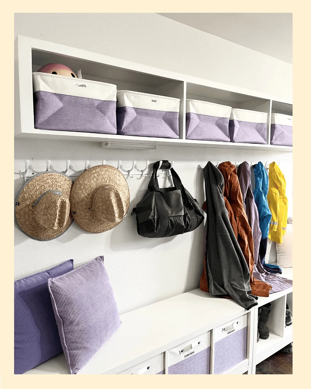 Organized mudroom with labeled storage bins, wall hooks for coats and bags, and built-in cubby storage