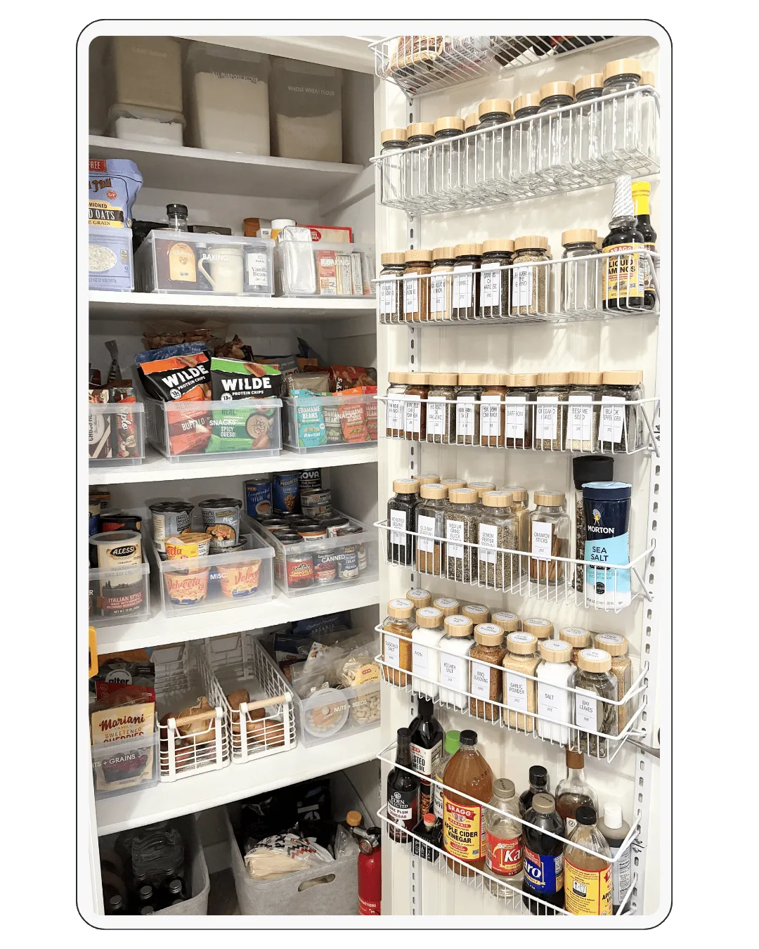 Fully organized pantry with labeled spice jars, clear food containers, and categorized shelves for easy kitchen storage
