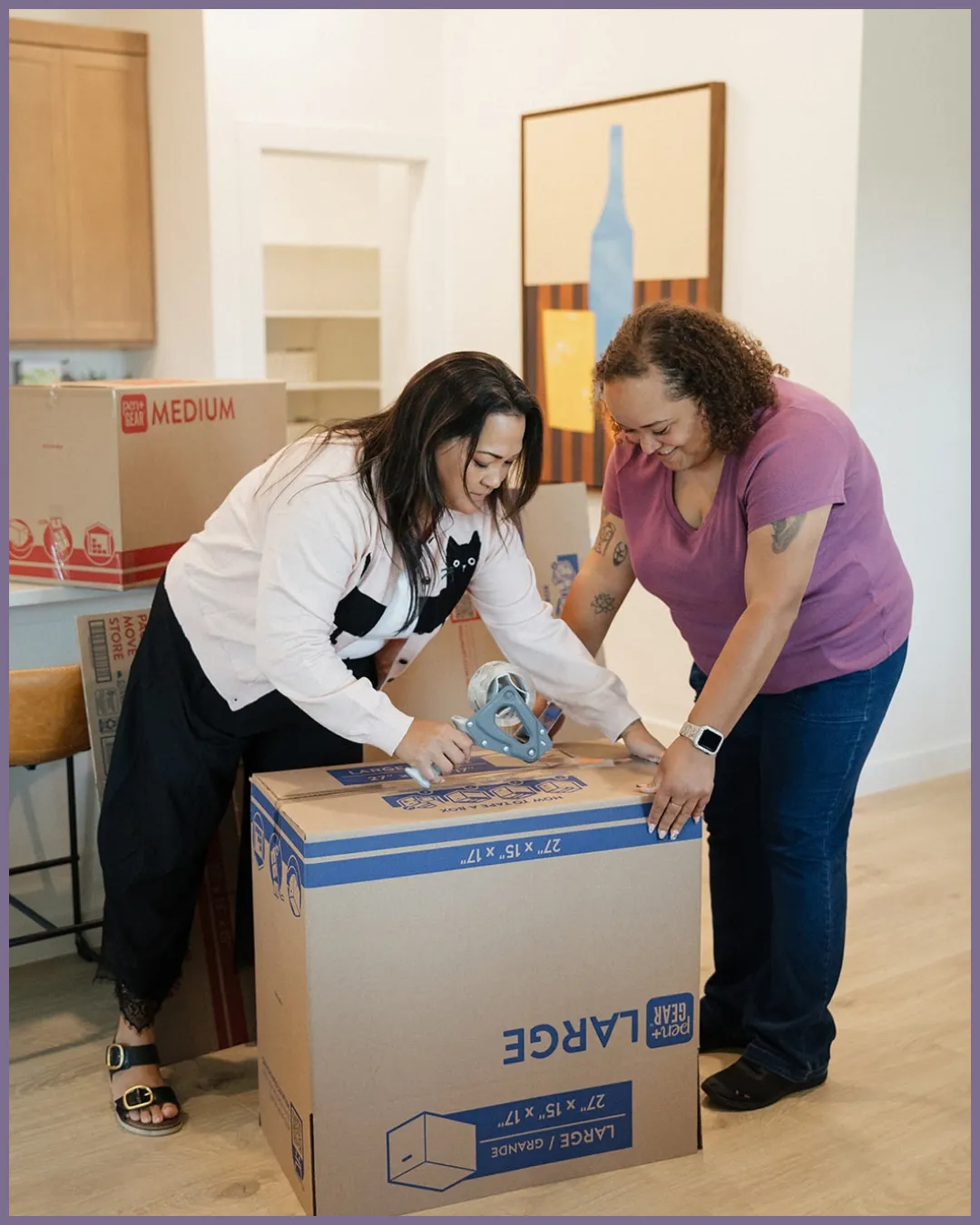 Stacked moving boxes, houseplants, and packing supplies in a living room during a home move