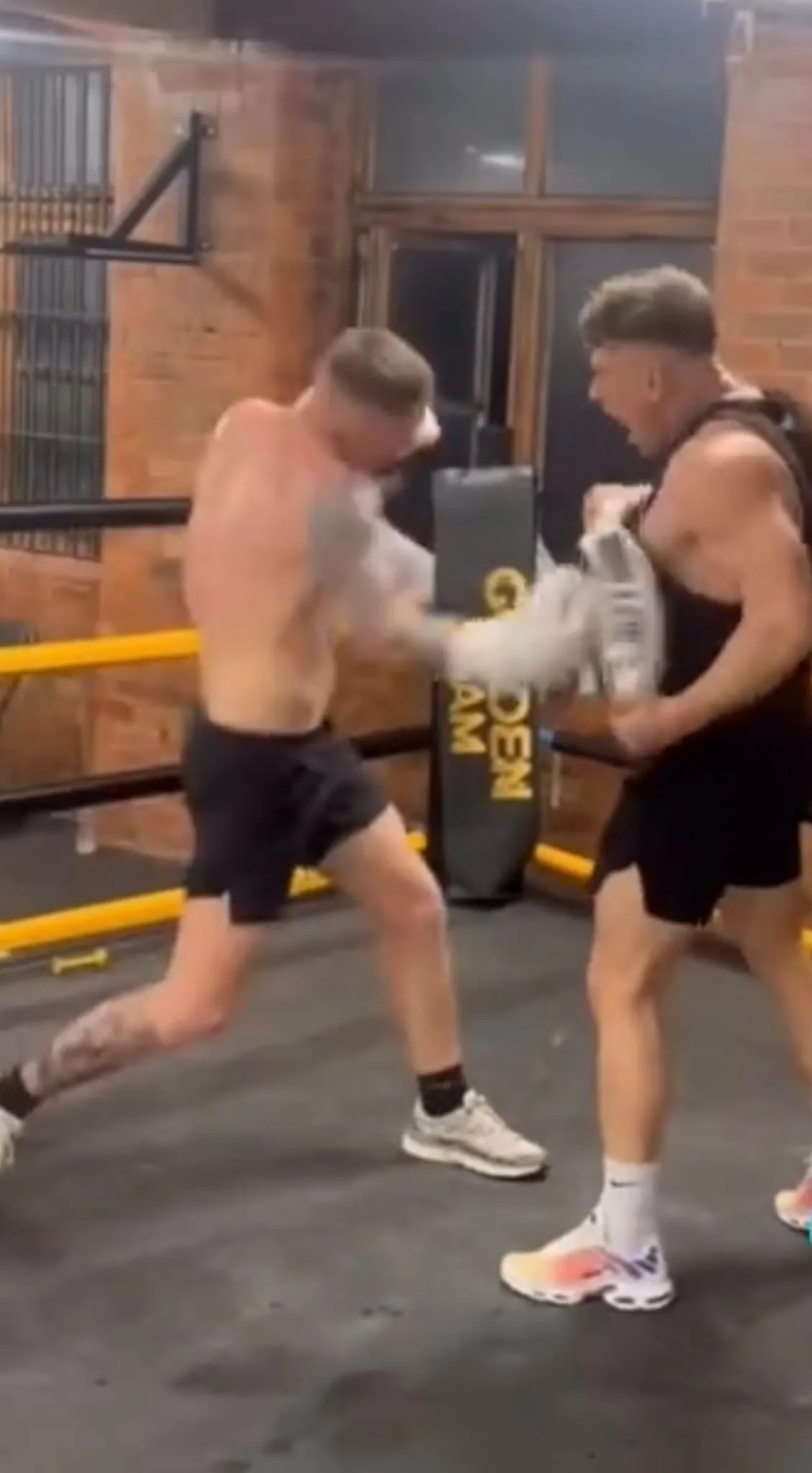 2 men holding blue and white labeled bottle