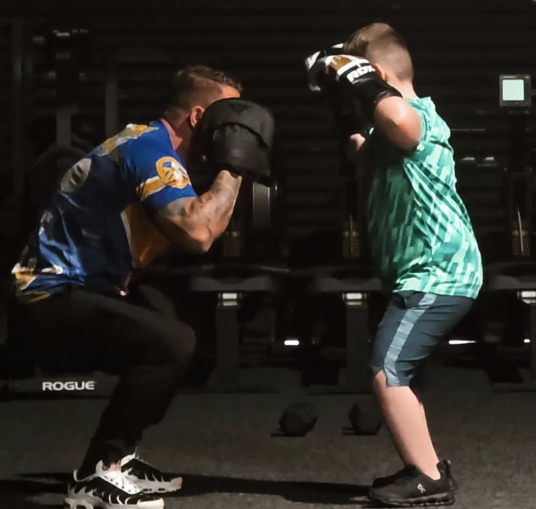 man red and black top running on farm road