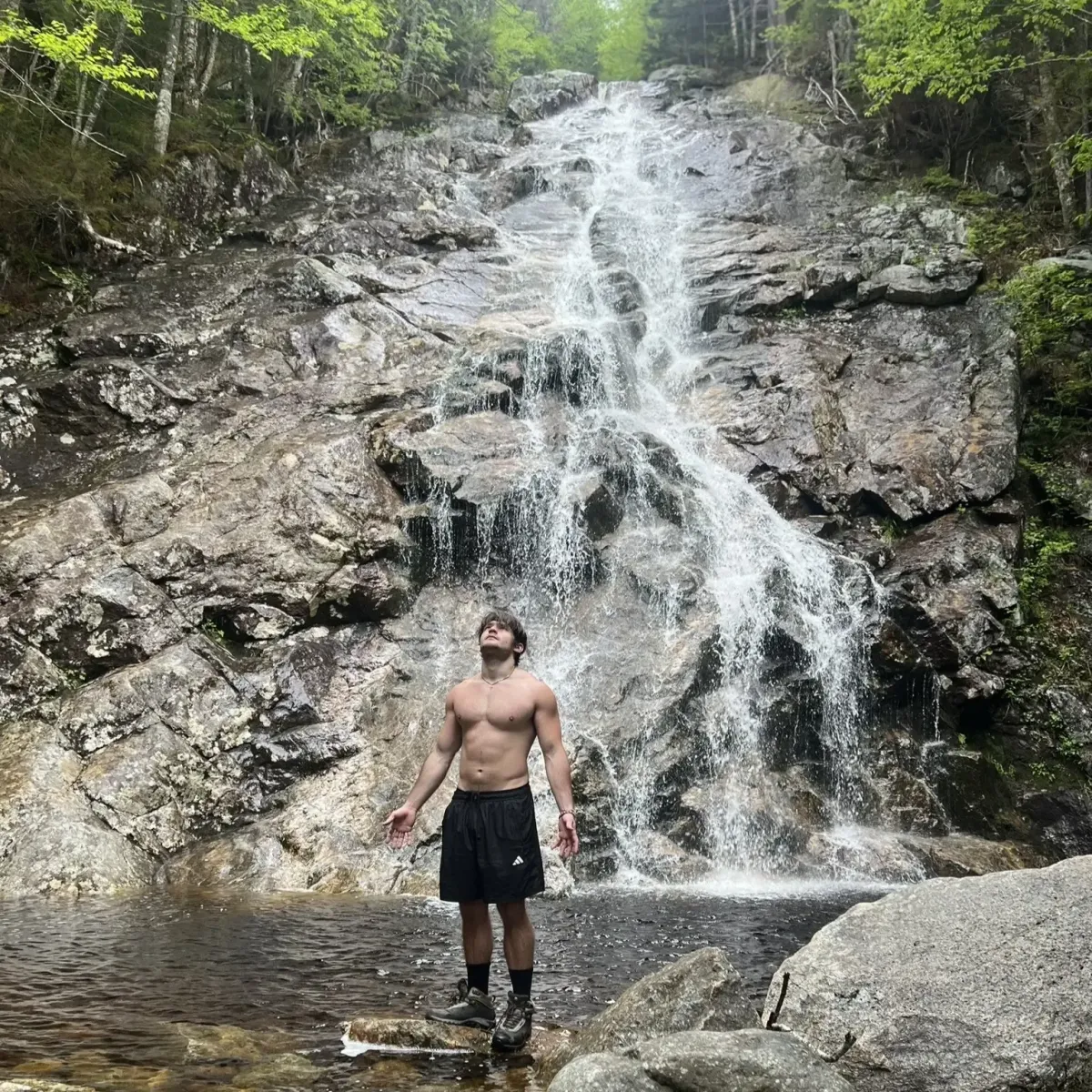 Coach Keyed standing shirtless under waterfall showing physique results and personal transformation representing high ticket 1 on 1 coaching in the Courageous Quantum Leap program
