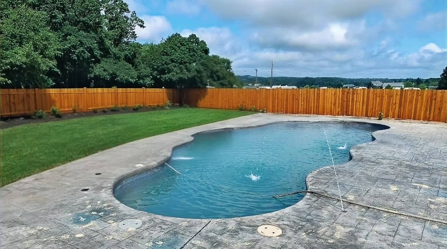 A man standing next to a swimming pool