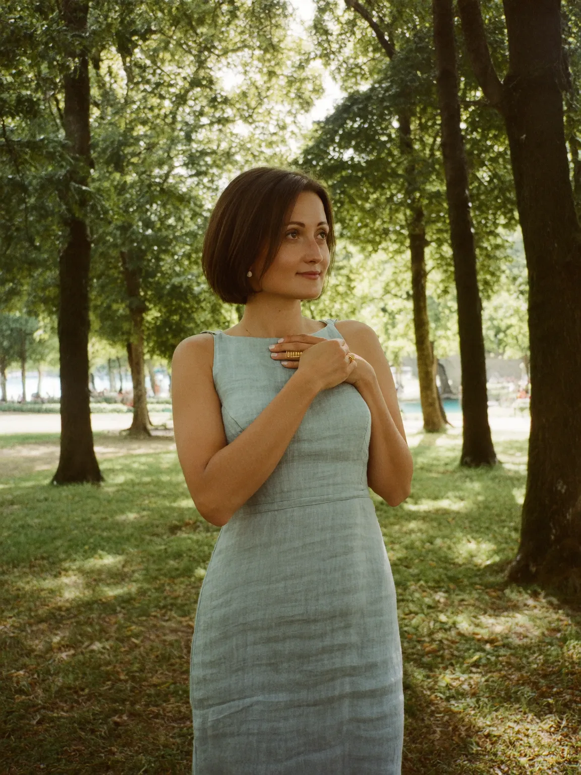 A woman standing in a stream holding a large bowl