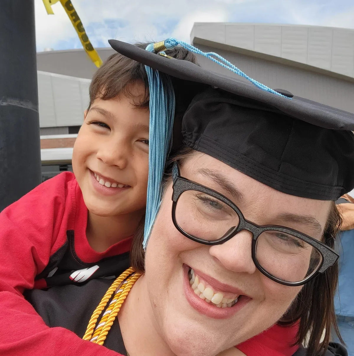 Picture of Jessica Tran in graduation outfit with child