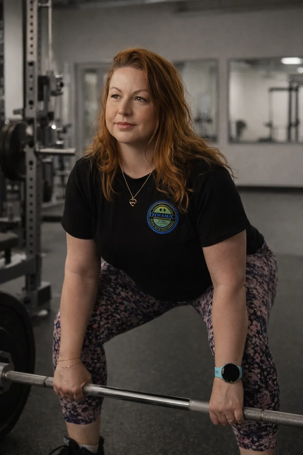 Coach Ace doing a slow, controlled deadlift in a gym.