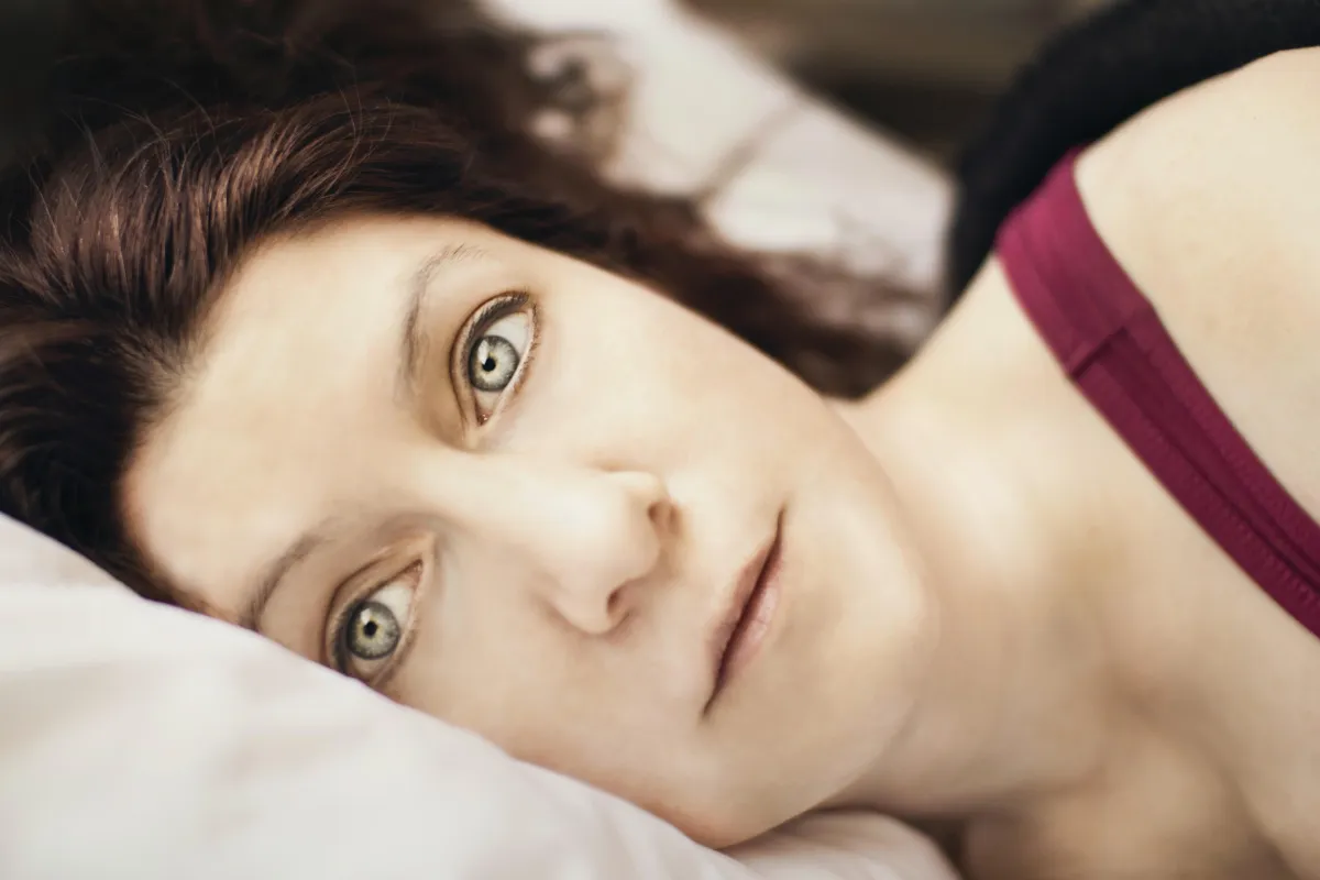 Image of sad woman lying down feeling sick and tired of being sick and tired