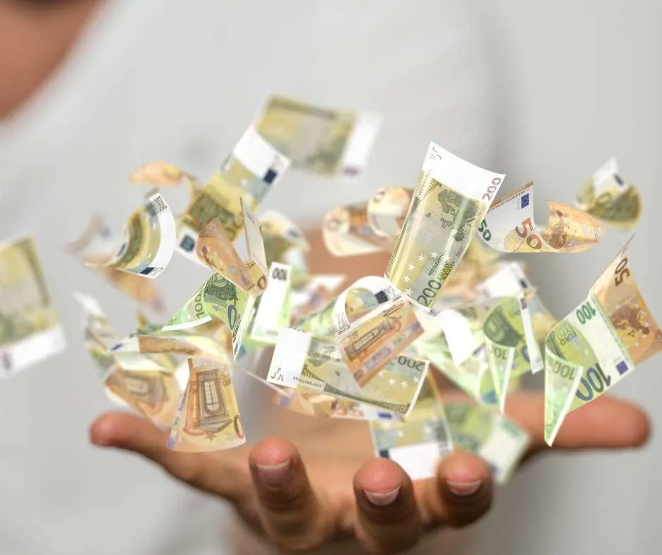 Image of money falling into a hand representing getting the rewards