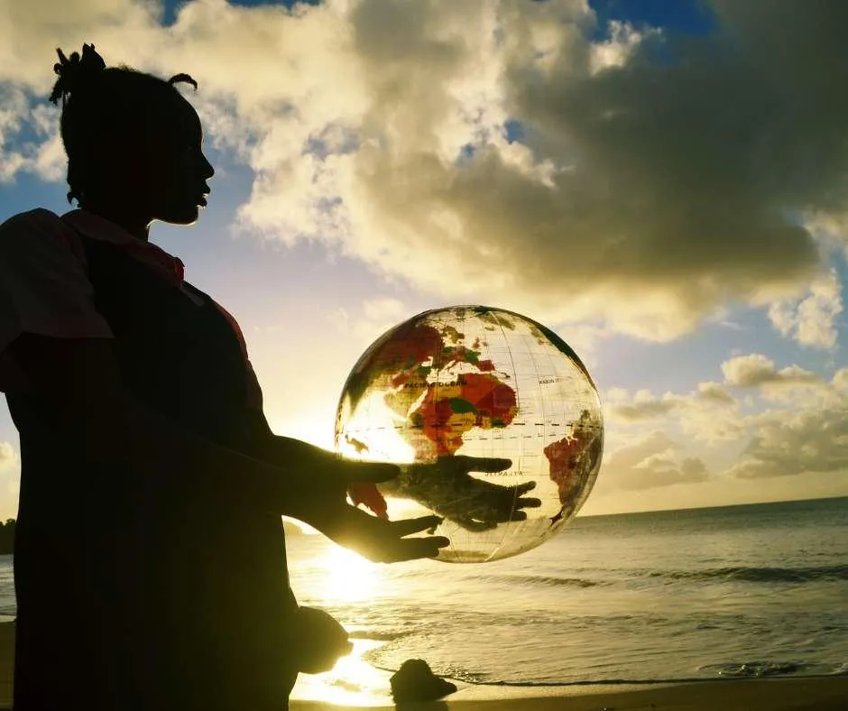 Shadow image of a woman holding the world in her hands at sunset