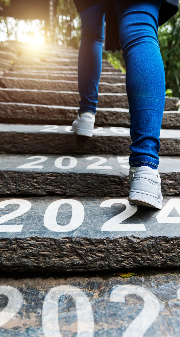 Woman walking up outdoor steps with 2024 2025 years written indicating stepping into your best self