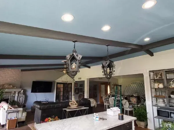 Modern living room ceiling with fresh blue paint and decorative lighting installation