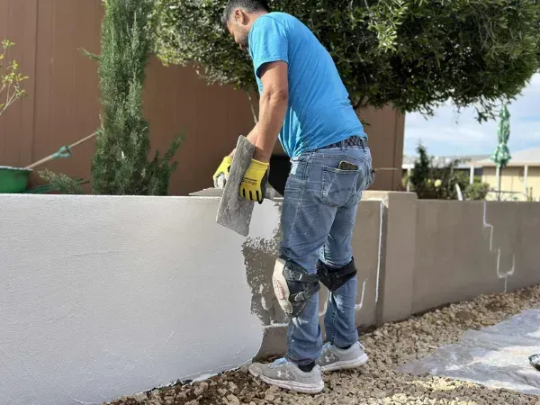 Handyman performing stucco repair on an exterior wall