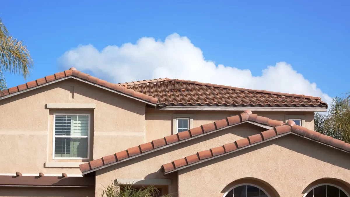 House with Spanish tile roof and stucco exterior under clear blue sky