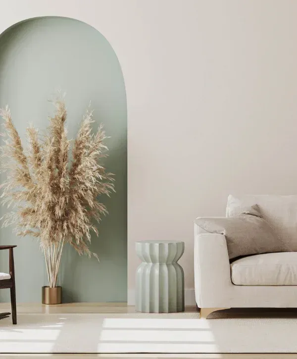 Modern living room with sage green wall and minimalist beige furniture 