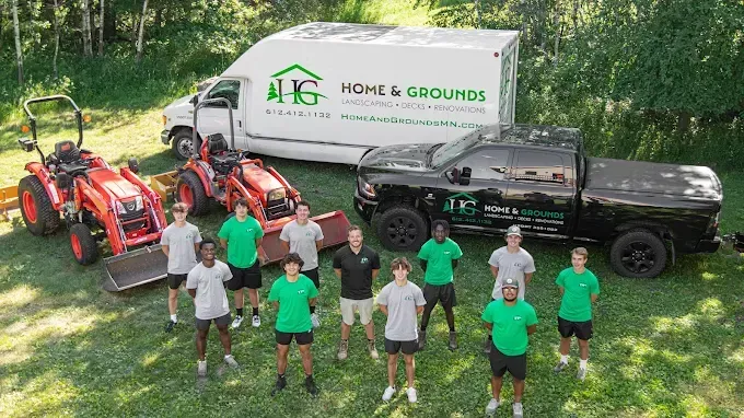 Home & Grounds landscaping crew with branded trucks and tractors in Twin Cities