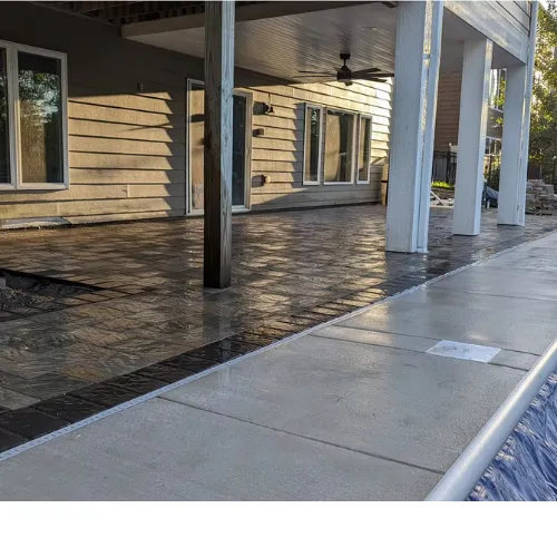 Stamped concrete patio installed beneath elevated deck for outdoor entertainment area