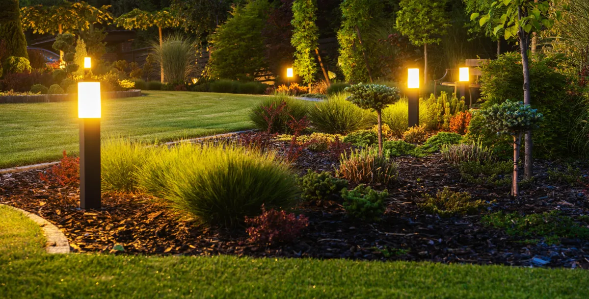 Evening backyard patio with chairs, stamped finish, and lighting
