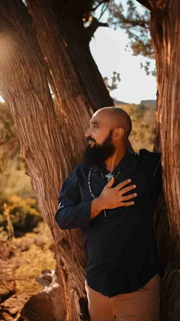 Professional shot of Michael with hand over heart, looking at the landscape.