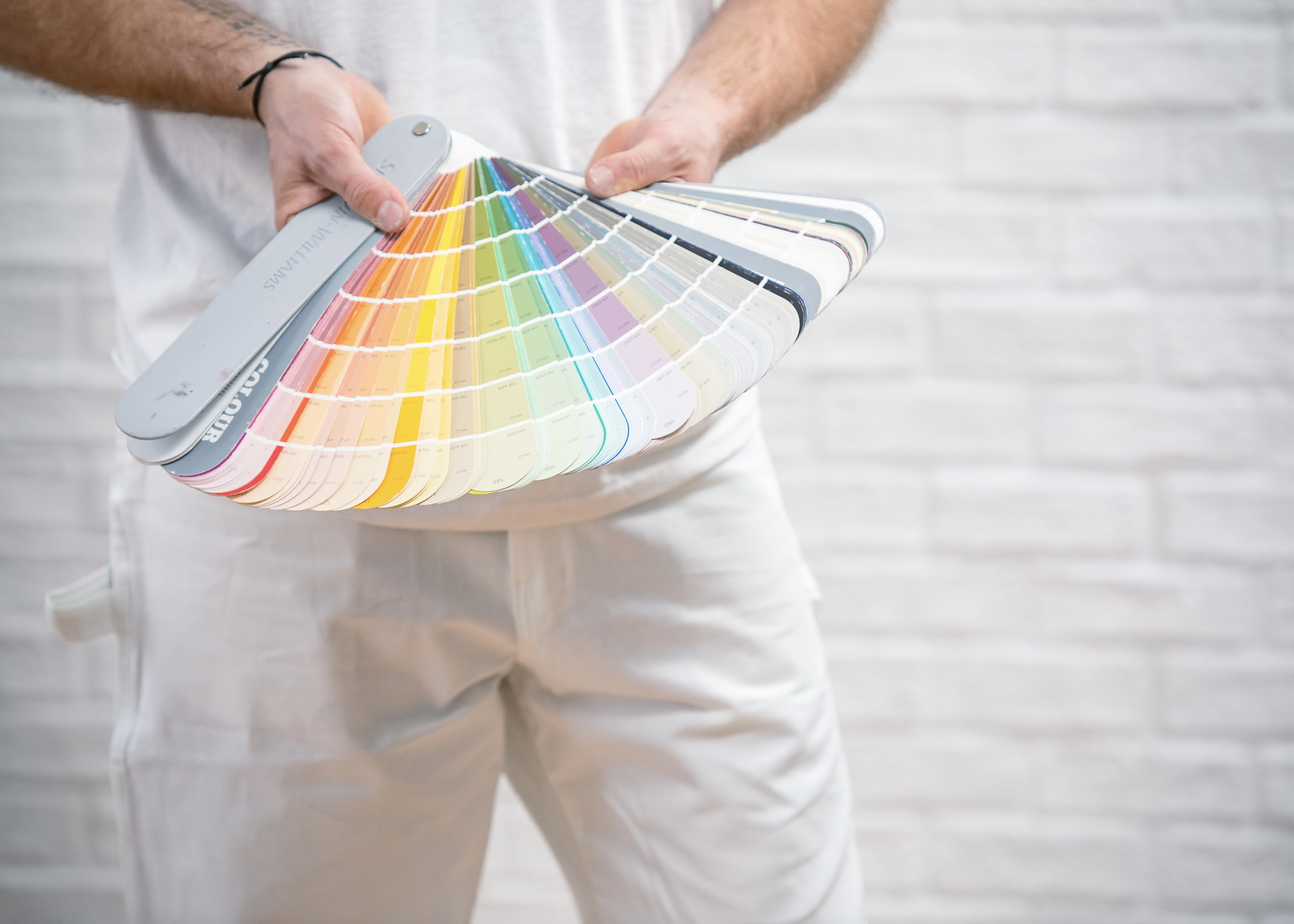 Altona Painting contractor holding a fan deck of paint colours indoors