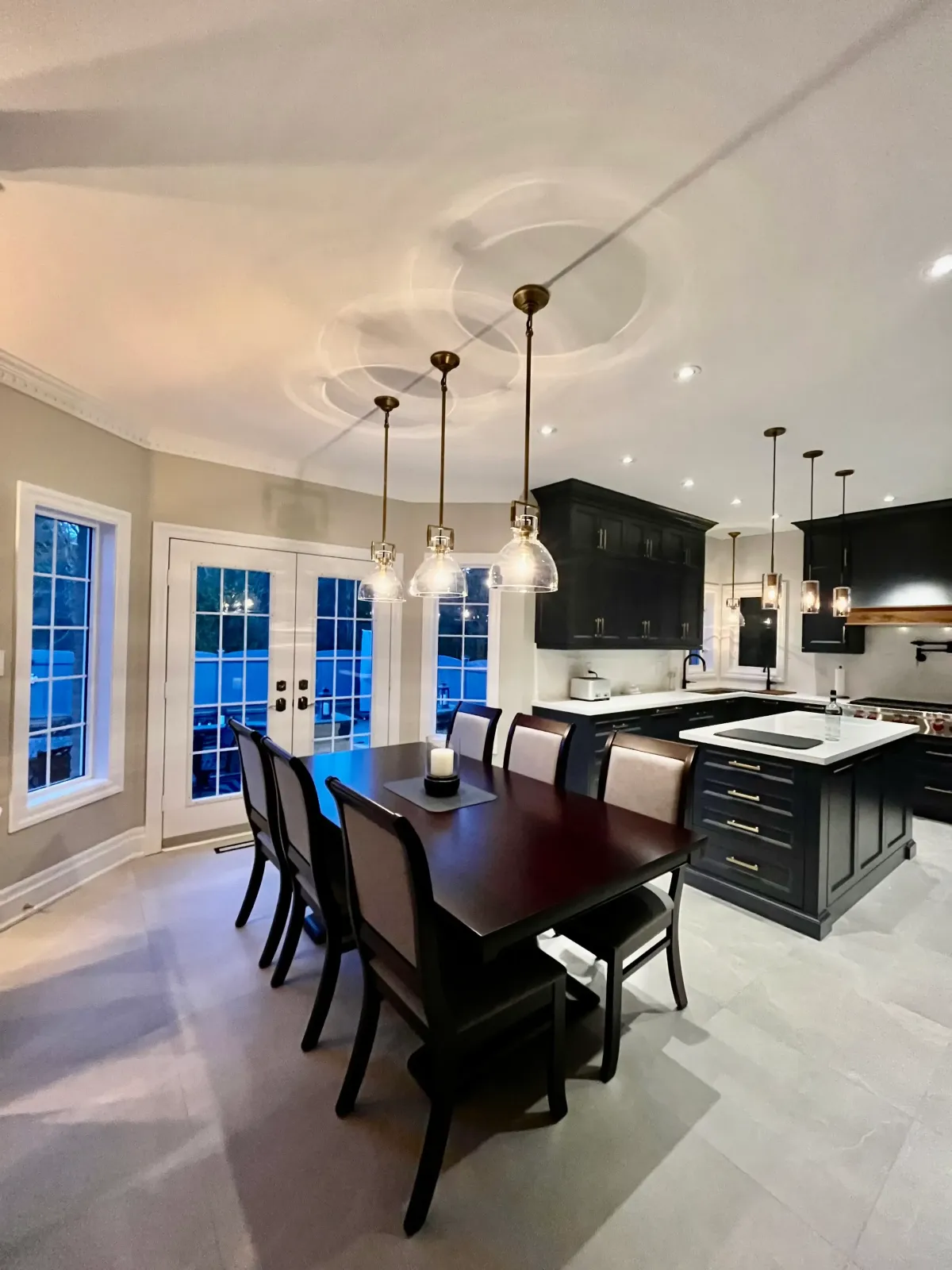 Navy blue kitchen cabinetry with white quartz island and brass pendant lighting — kitchen painting project in Midtown Toronto by Altona Painting