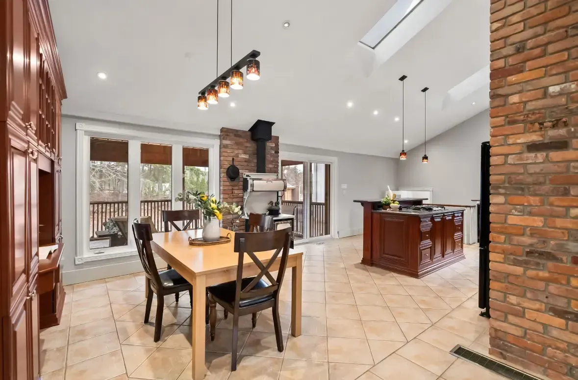 Bright kitchen and dining area with exposed brick and skylight in a Lindsay, Ontario home — interior painting by Altona Painting