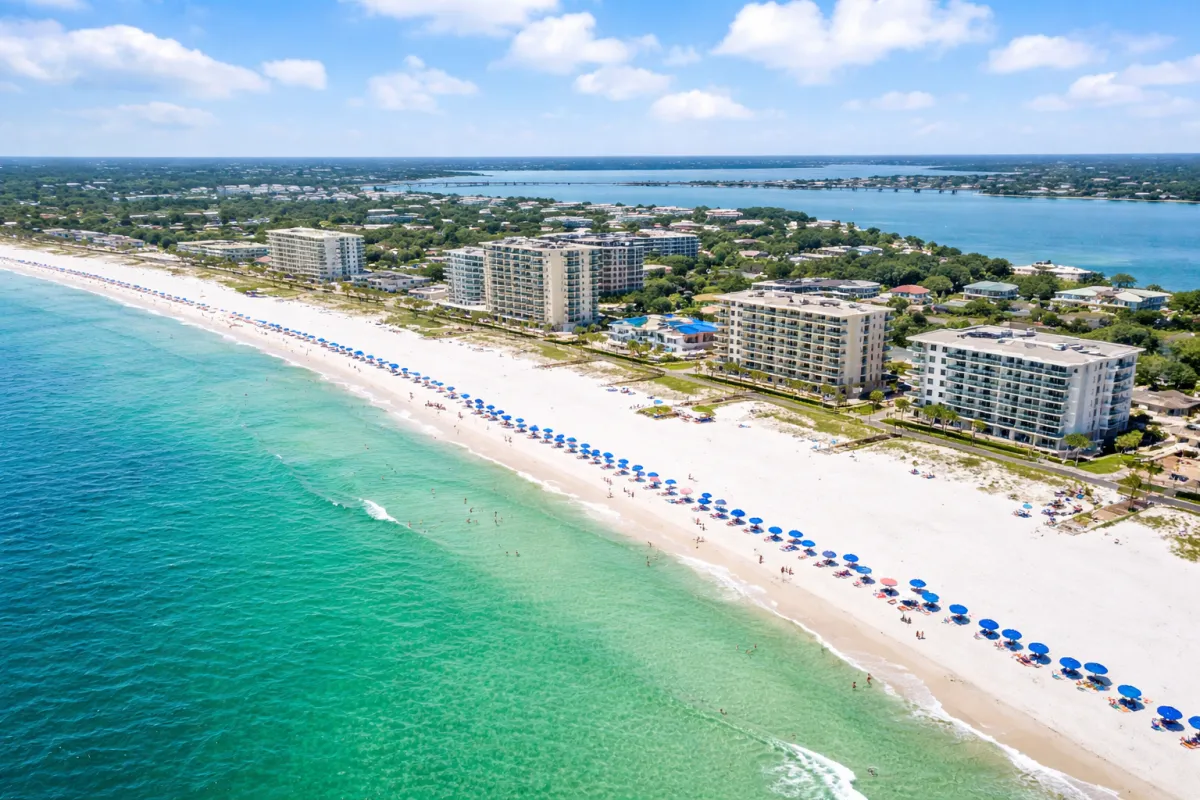 Aerial view of Navarre Beach, Florida, showing white sand beaches, turquoise Gulf waters, and the Navarre Beach Fishing Pier on a sunny day