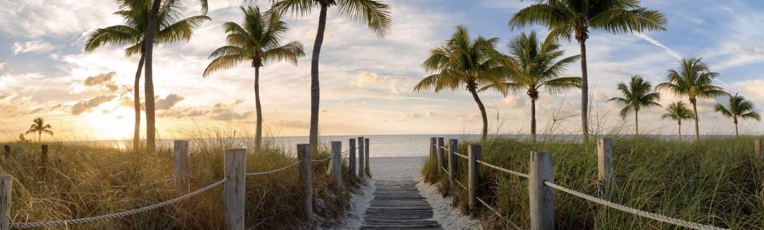 Scenic waterfront pathway with palm trees along the Emerald Coast near Valparaiso, Florida at sunset