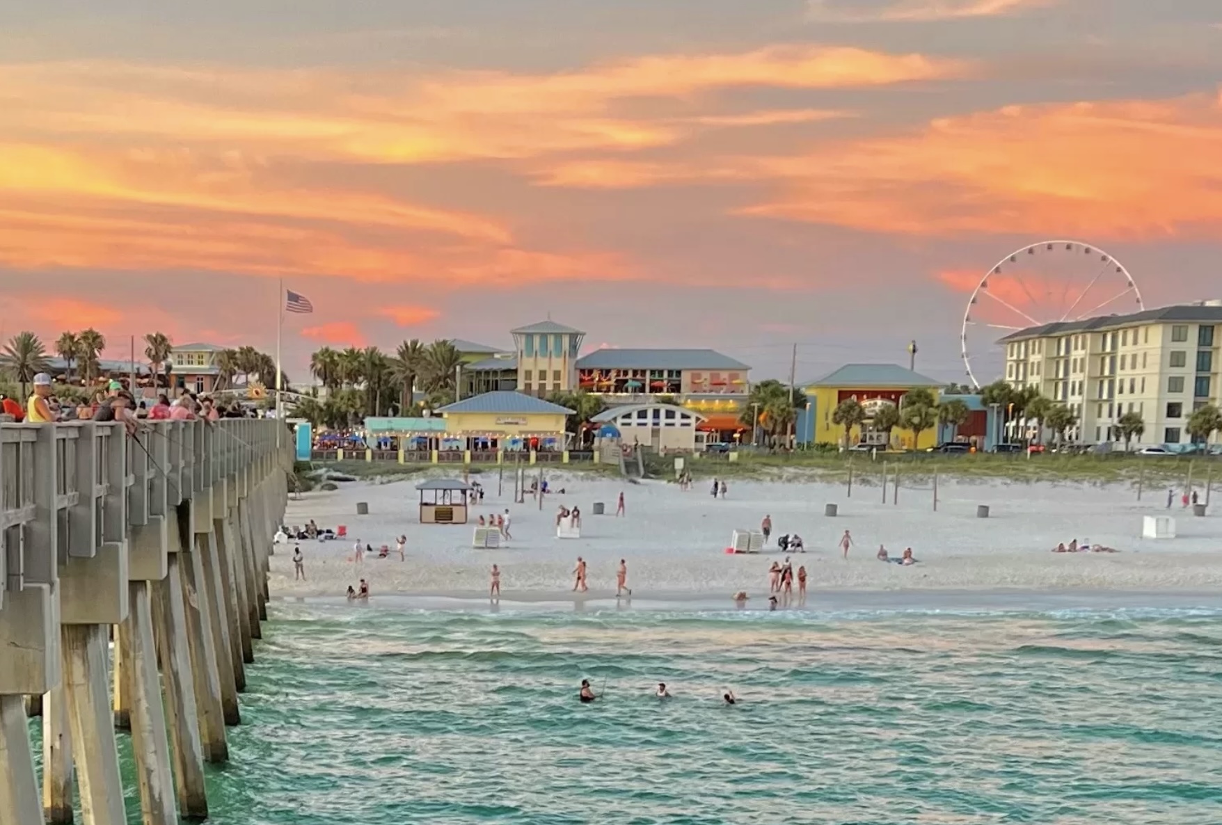 Sunset view of Panama City Beach, Florida with the pier, white sand beach, beachfront attractions, and Gulf of Mexico shoreline