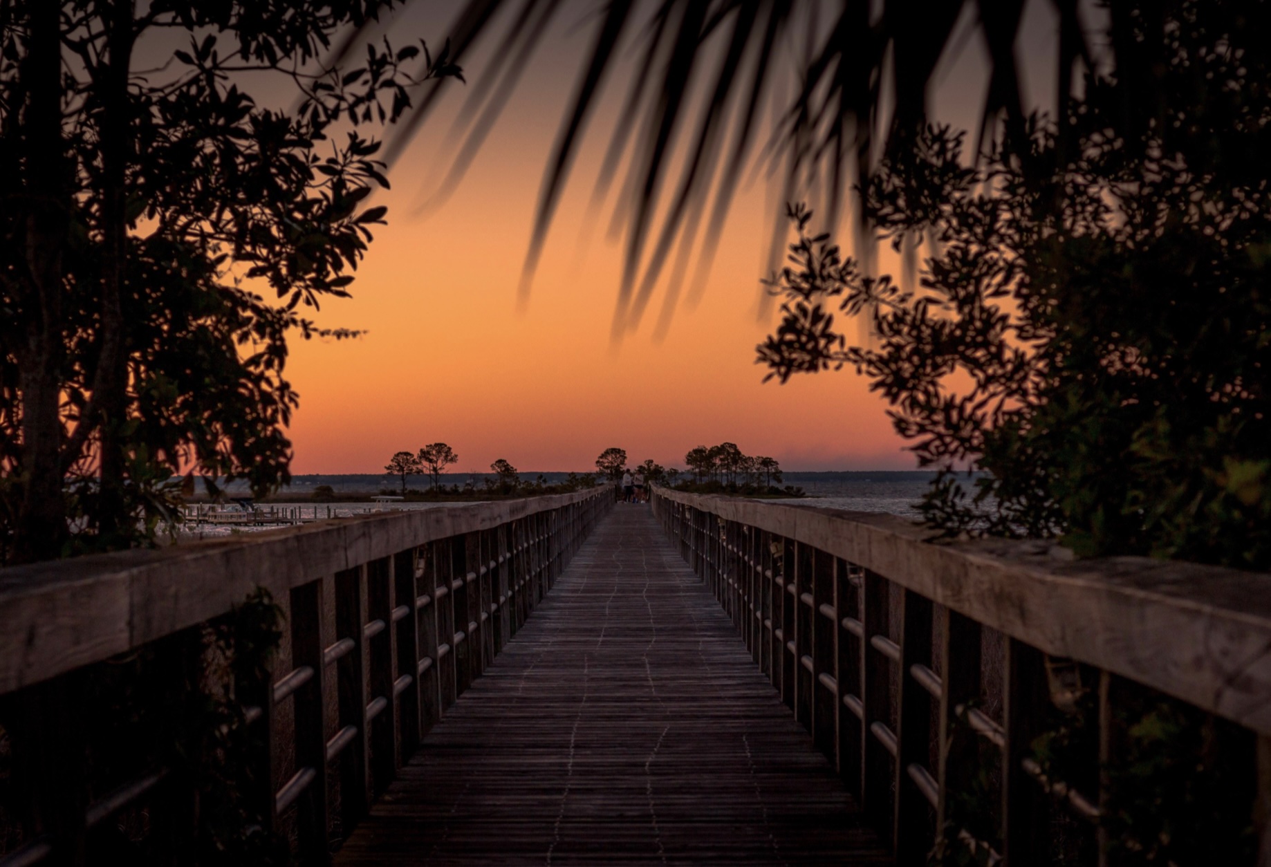 Wooden boardwalk at sunset in Point Washington, Florida, overlooking coastal dunes and water along the Emerald CoastAerial view of Blue Mountain Beach, FL showing white sand shoreline, emerald Gulf waters, and beachfront homes along Scenic Highway 30A.