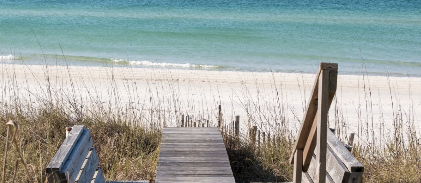 Wooden beach boardwalk leading through sand dunes to the shoreline in Point Washington, Florida along the Gulf Coast